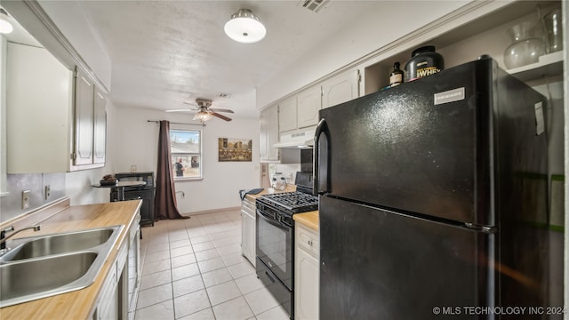 kitchen featuring white cabinets, black appliances, light tile patterned flooring, sink, and wooden counters