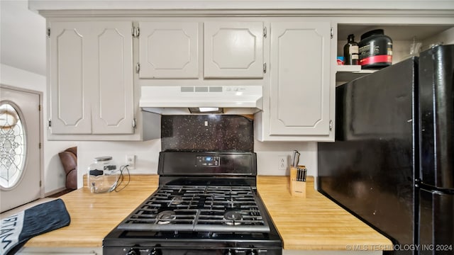 kitchen with ventilation hood, white cabinetry, wood counters, and black appliances