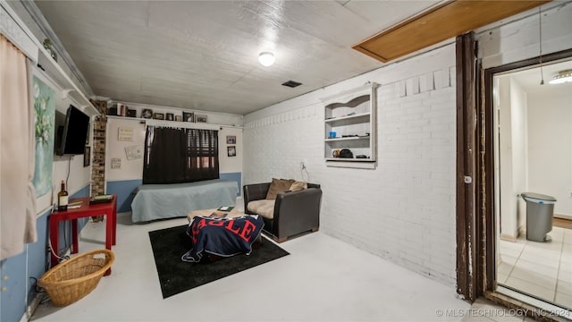 interior space featuring brick wall and concrete flooring