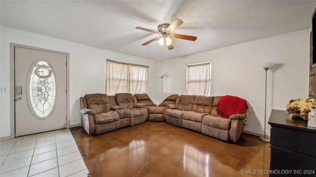 living room with tile patterned flooring, a textured ceiling, and ceiling fan