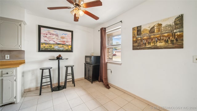 tiled dining area with ceiling fan