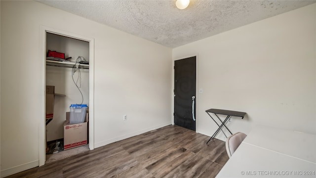 bedroom featuring a textured ceiling, hardwood / wood-style flooring, and a closet