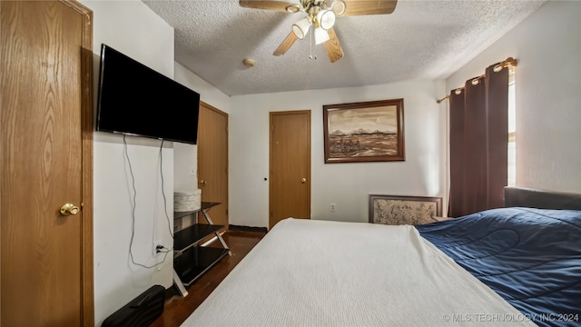 bedroom with dark hardwood / wood-style flooring, a textured ceiling, and ceiling fan