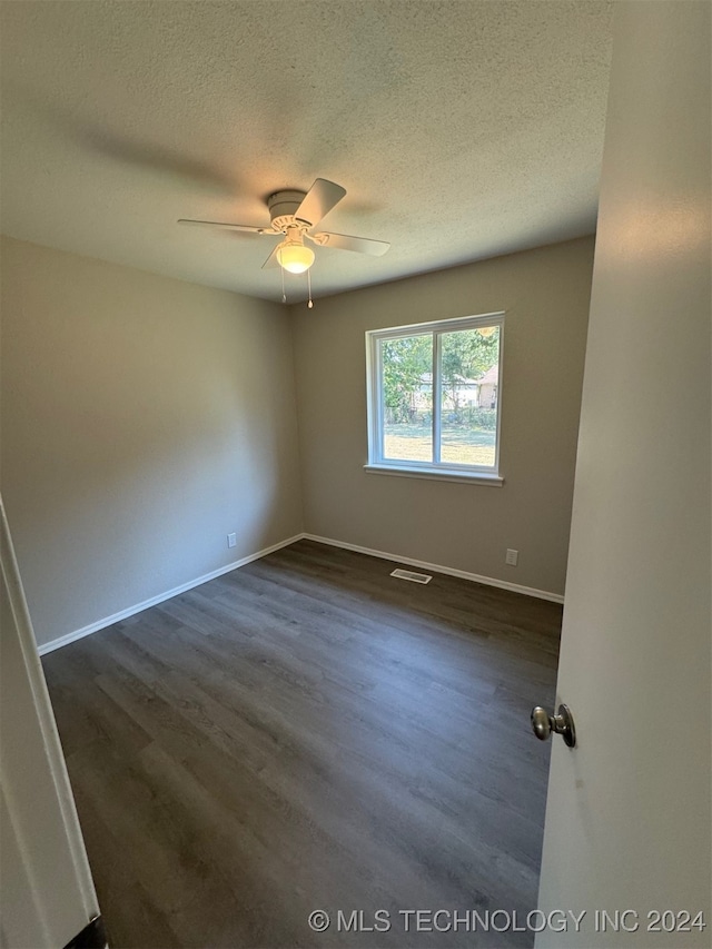 spare room featuring a textured ceiling, dark hardwood / wood-style floors, and ceiling fan