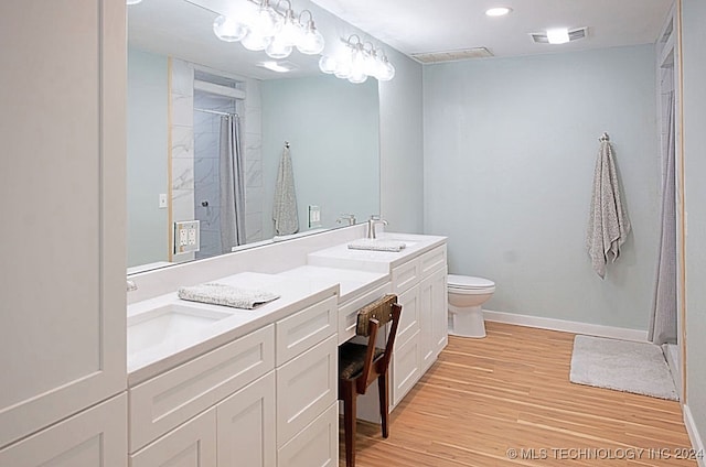 bathroom featuring hardwood / wood-style floors, vanity, toilet, and a shower with shower curtain