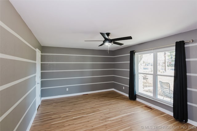 empty room featuring hardwood / wood-style flooring, ceiling fan, and plenty of natural light