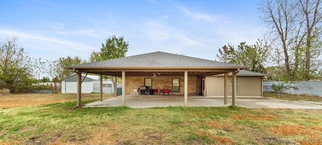 rear view of house featuring a yard, a garage, and an outdoor structure