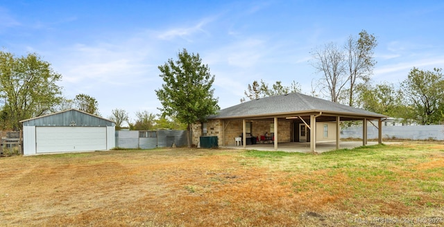 back of house with a yard, an outbuilding, and a garage