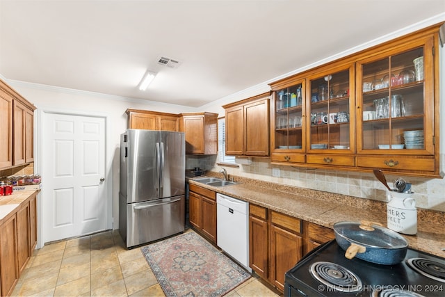 kitchen featuring range with electric cooktop, white dishwasher, sink, stainless steel refrigerator, and tasteful backsplash