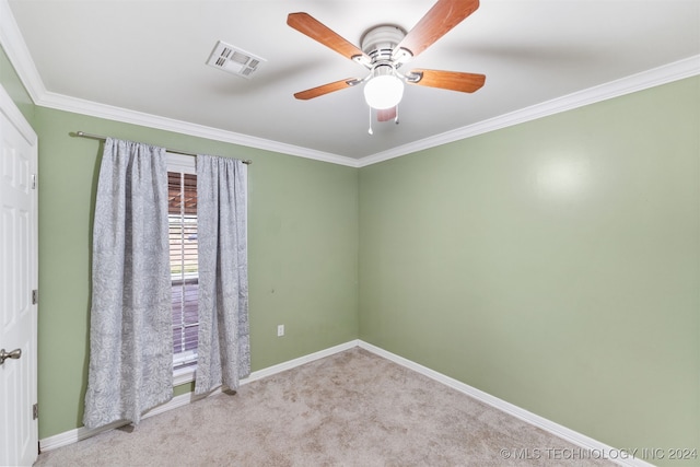 carpeted empty room featuring ceiling fan and crown molding