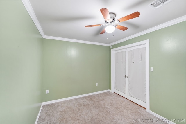 unfurnished bedroom featuring ceiling fan, light carpet, and crown molding