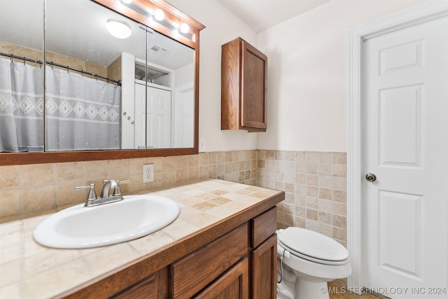 bathroom featuring tile walls, vanity, and toilet