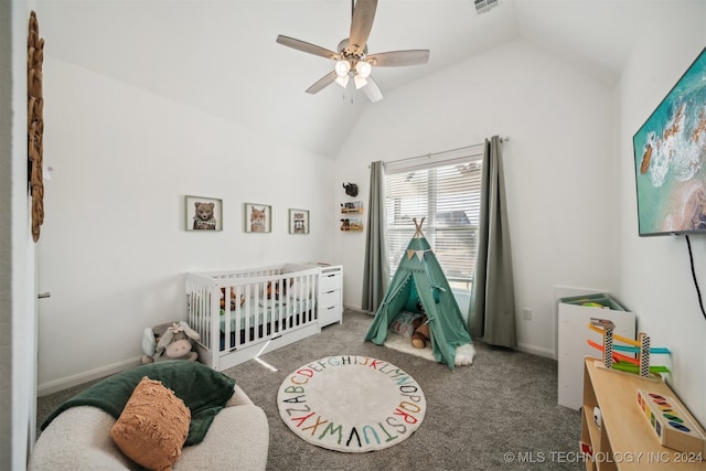 carpeted bedroom with ceiling fan, a crib, and vaulted ceiling