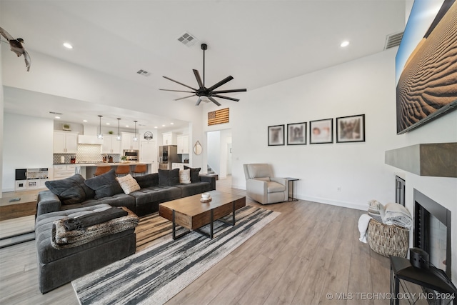 living room with light hardwood / wood-style floors and ceiling fan