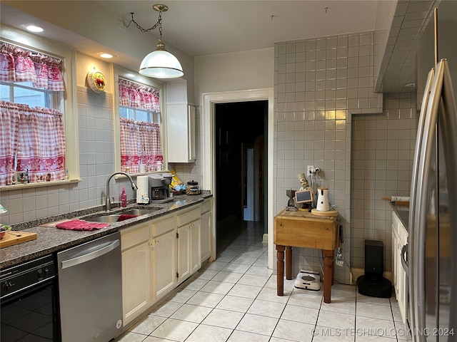 kitchen featuring stainless steel appliances, hanging light fixtures, sink, tasteful backsplash, and light tile patterned flooring