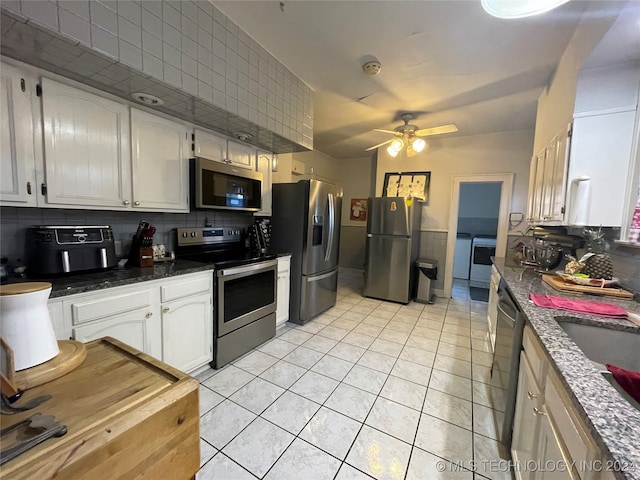 kitchen with light tile patterned flooring, backsplash, appliances with stainless steel finishes, white cabinets, and ceiling fan