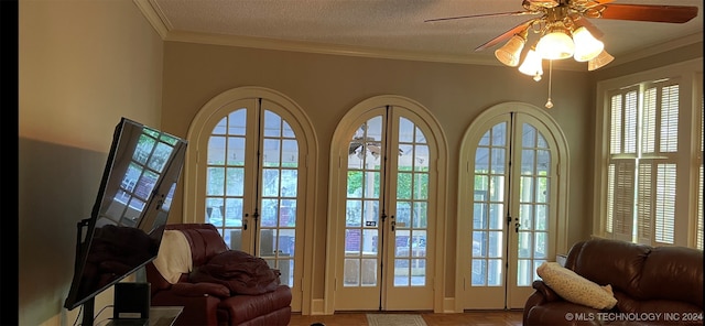 entryway featuring ceiling fan, a healthy amount of sunlight, french doors, and ornamental molding