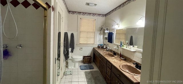 bathroom featuring toilet, tile walls, tile patterned flooring, a textured ceiling, and vanity