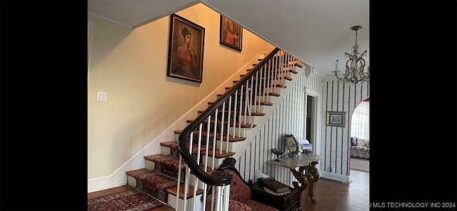 stairs featuring a chandelier