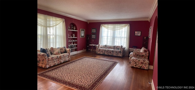 living room with built in features, a textured ceiling, crown molding, and wood-type flooring