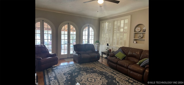 living room with french doors, tile patterned flooring, a textured ceiling, and crown molding