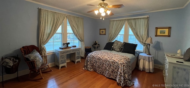 bedroom with multiple windows, hardwood / wood-style floors, and ceiling fan