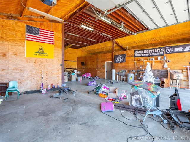 garage featuring wooden walls and a garage door opener