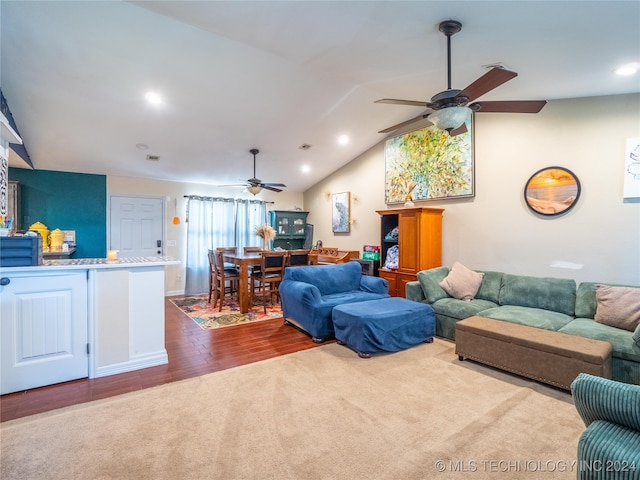 living area with ceiling fan, recessed lighting, carpet flooring, wood finished floors, and vaulted ceiling