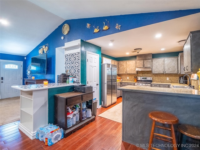 kitchen featuring open shelves, stainless steel appliances, a sink, a peninsula, and under cabinet range hood