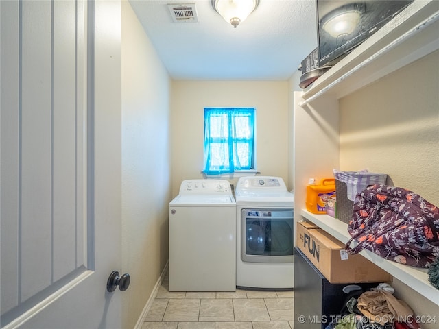 washroom with washing machine and dryer and light tile patterned floors