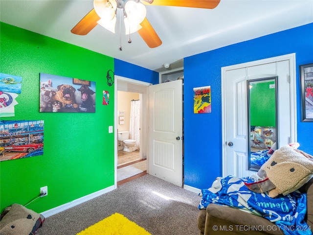 carpeted bedroom featuring ceiling fan and ensuite bath