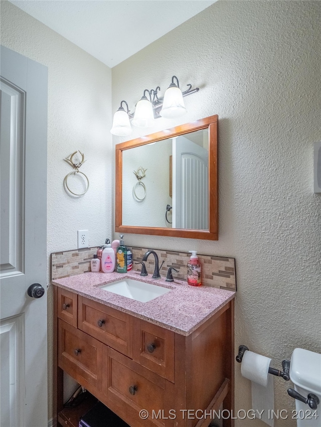 half bath featuring backsplash, a textured wall, vanity, and toilet