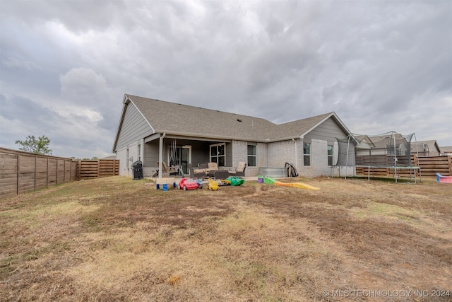 rear view of house with a patio area and a trampoline