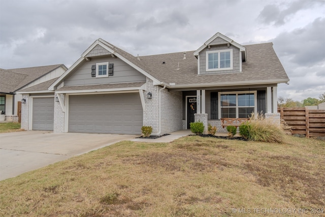 craftsman house featuring a porch, a front lawn, and a garage