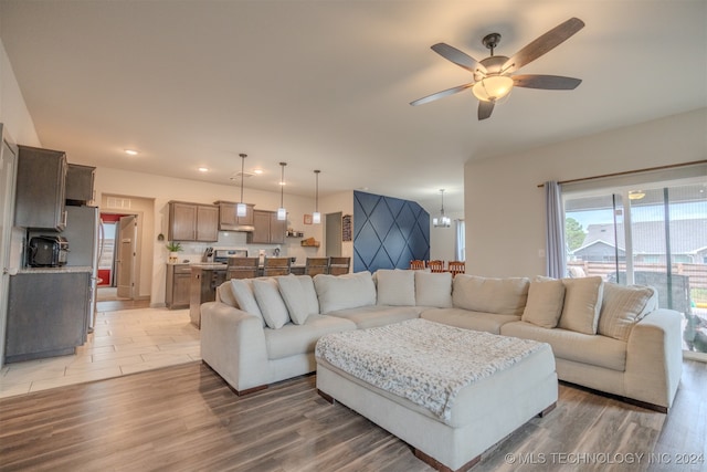 living room featuring hardwood / wood-style floors and ceiling fan with notable chandelier