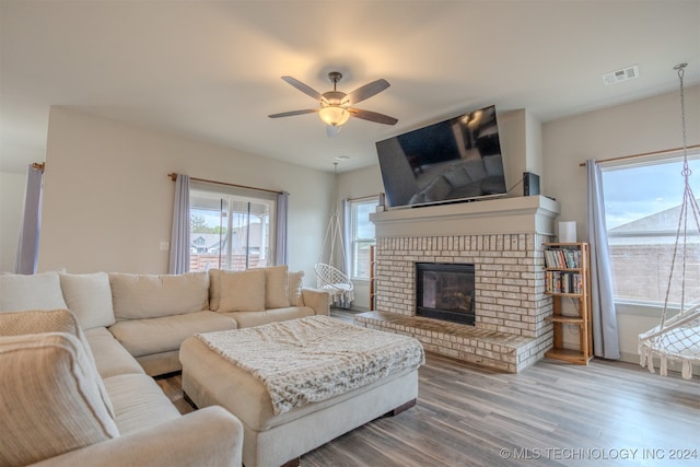 living room featuring a fireplace, wood-type flooring, and ceiling fan