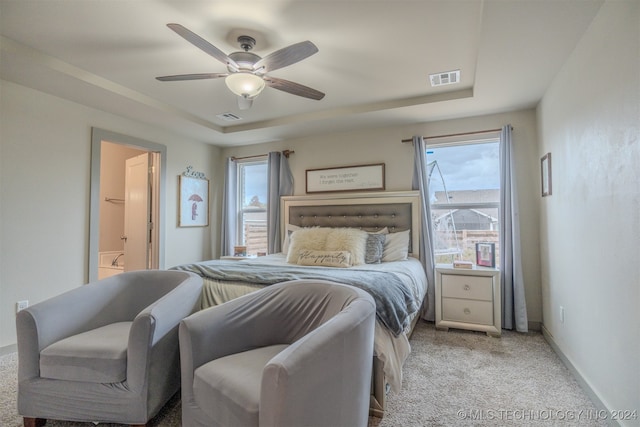 carpeted bedroom featuring connected bathroom, ceiling fan, and multiple windows