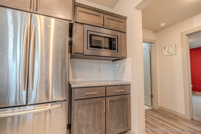 kitchen with stainless steel appliances, tasteful backsplash, and light wood-type flooring