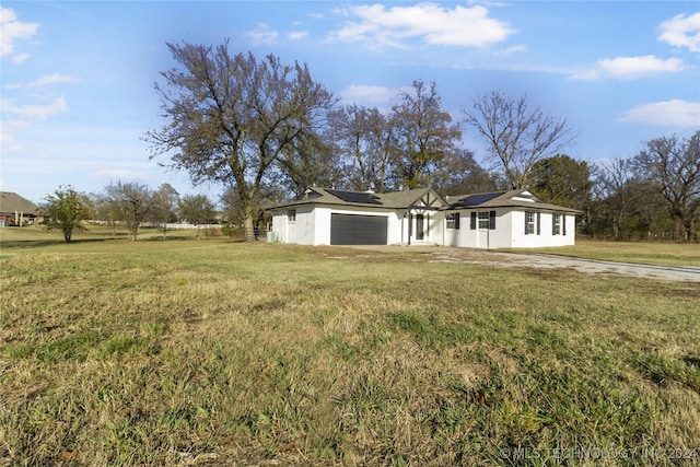 single story home with a garage and a front lawn