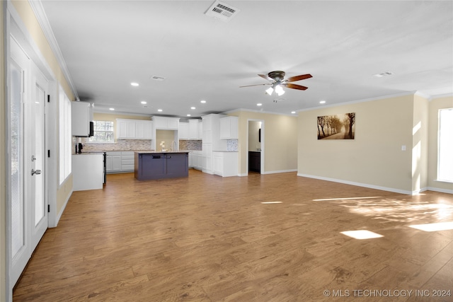 unfurnished living room with ceiling fan, ornamental molding, and light hardwood / wood-style flooring