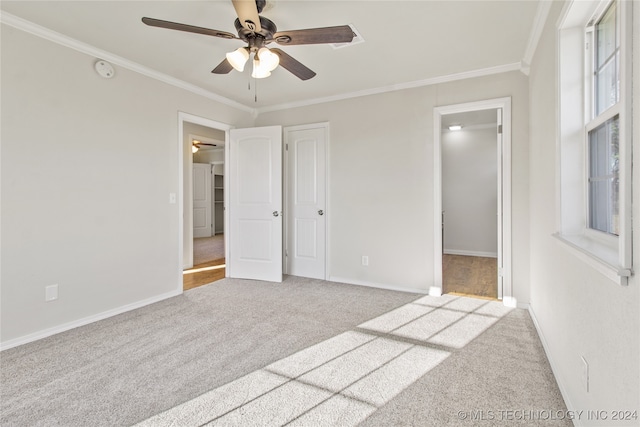 carpeted empty room with ceiling fan and crown molding