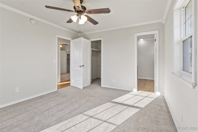 unfurnished bedroom with light colored carpet, ceiling fan, a closet, and ornamental molding