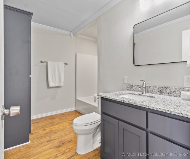 bathroom featuring wood-type flooring, vanity, toilet, and crown molding