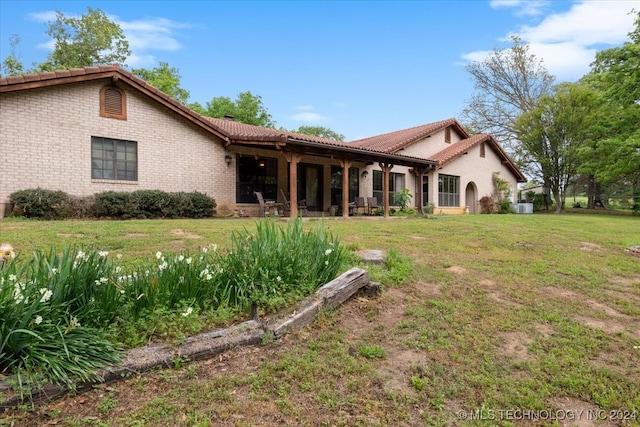 back of property with a lawn