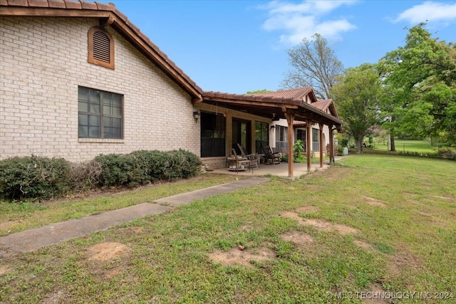 exterior space with a patio area and a lawn