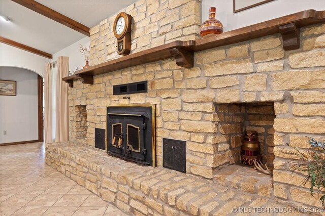 unfurnished living room with vaulted ceiling with beams and light tile patterned floors