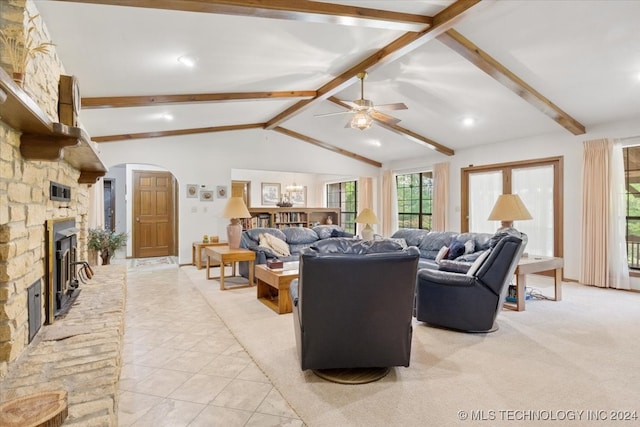 living room featuring lofted ceiling with beams, a stone fireplace, light tile patterned floors, and ceiling fan