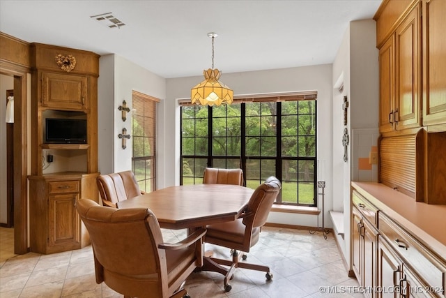 dining space with light tile patterned flooring and plenty of natural light