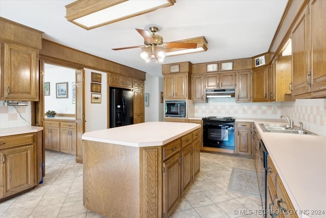 kitchen featuring sink, black appliances, a center island, and decorative backsplash