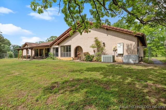 back of property with cooling unit and a lawn